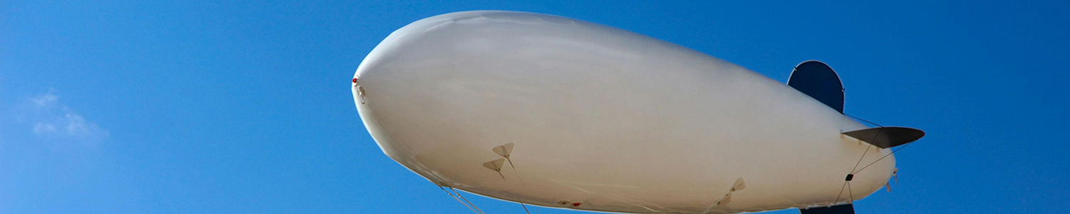 Photo of tethered airship against the sky.